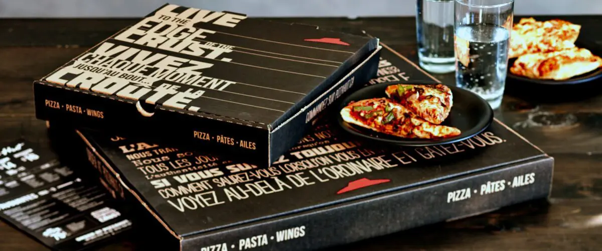 Pizza hut boxes and water on a table