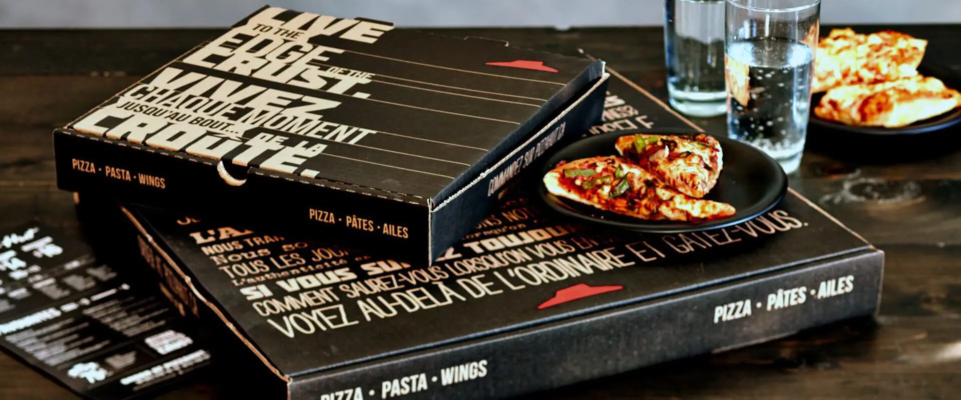 Pizza hut boxes and water on a table