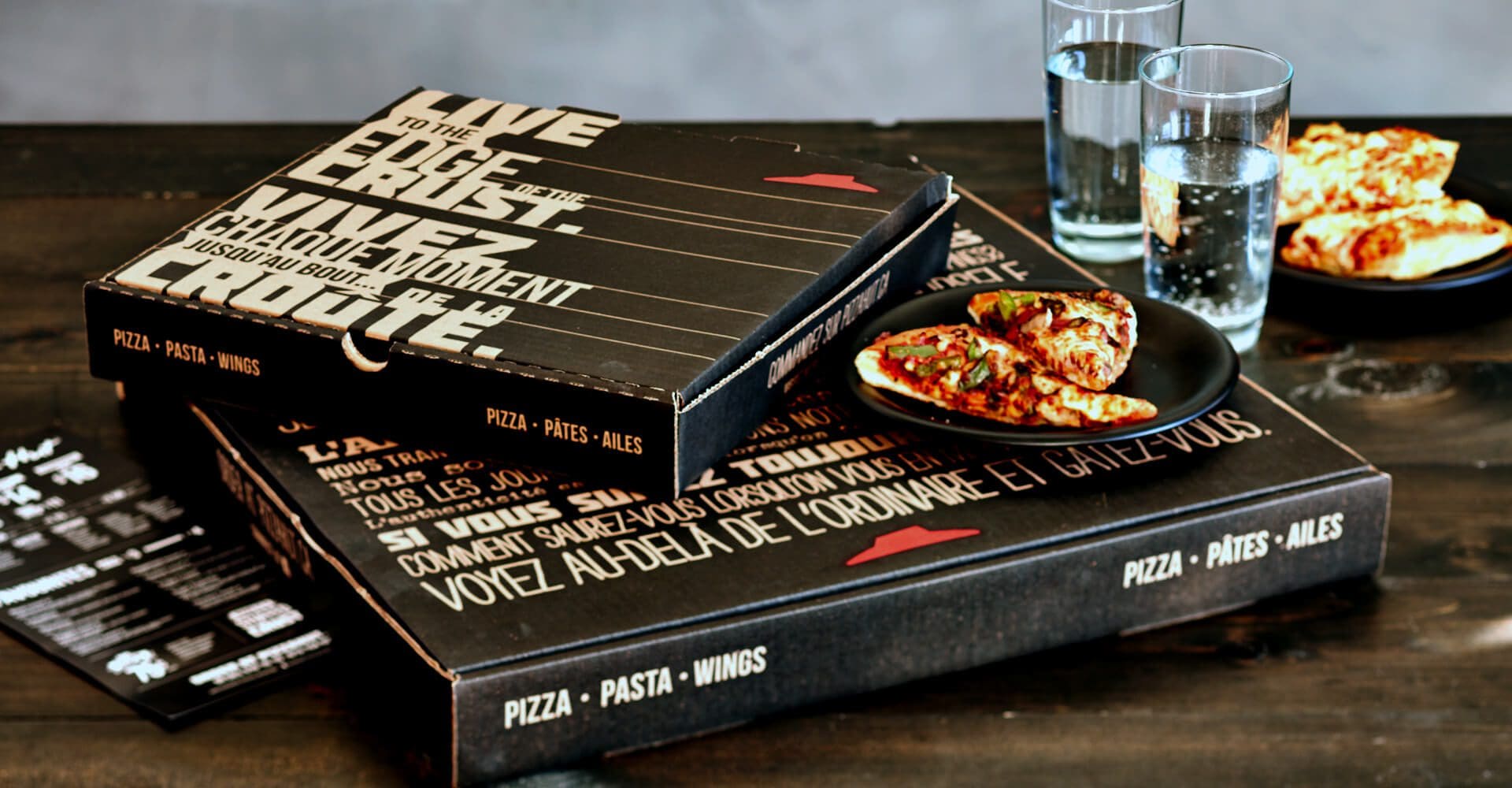 Pizza hut boxes and water on a table